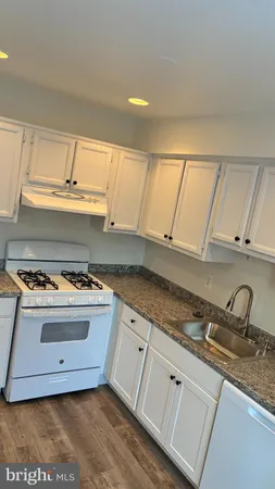 a kitchen with granite countertop a stove and a sink