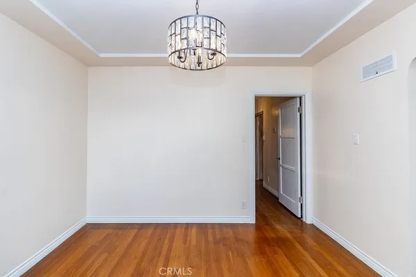 a view of a hallway with wooden floor and a table