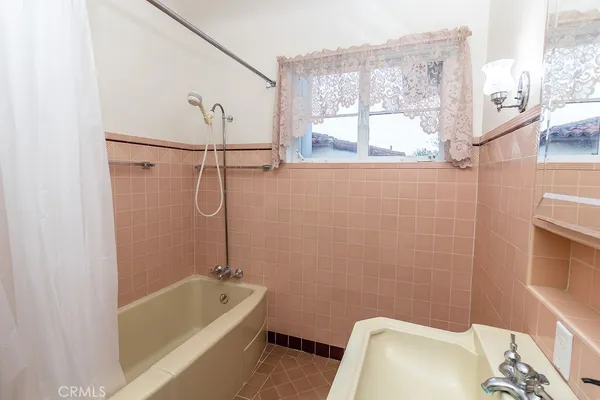 a bathroom with a tub a window and a shower