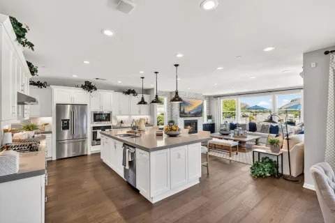 a kitchen with kitchen island granite countertop lots of counter top space a sink and appliances