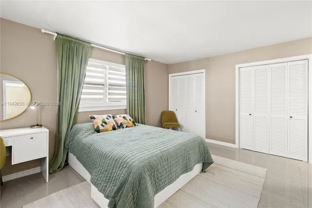 a bedroom with a bed a mirror and a window