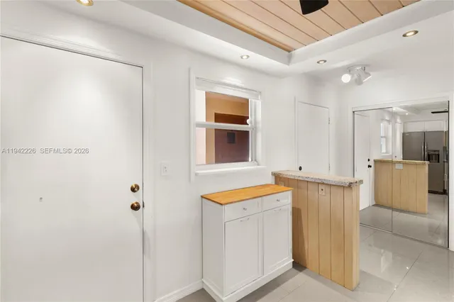 a kitchen with white cabinets and refrigerator