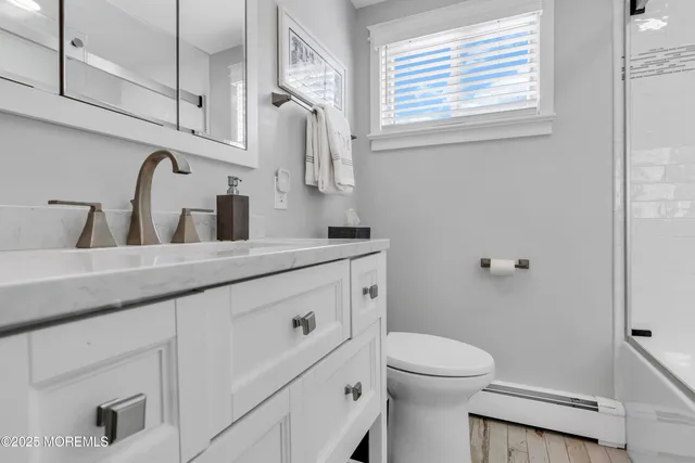 a bathroom with a granite countertop toilet sink and mirror