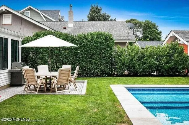 a view of a patio with table and chairs under an umbrella