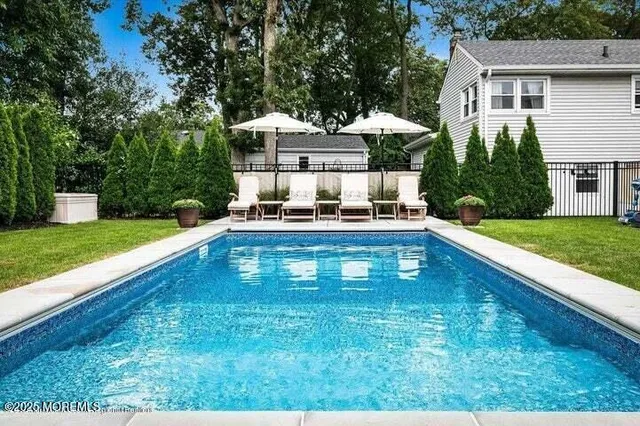 a front view of a house with swimming pool having outdoor seating
