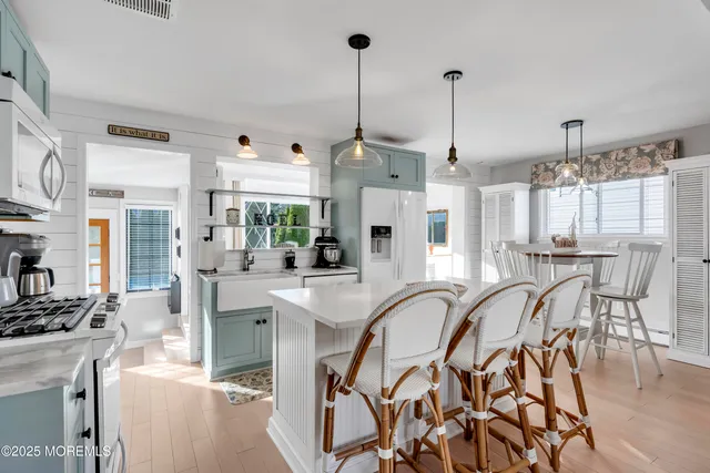 a dinning area with stainless steel appliances kitchen island granite countertop a table and chairs
