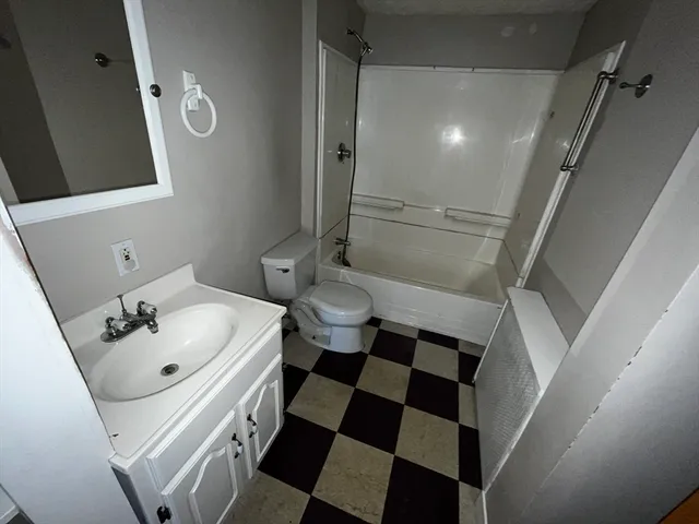 a bathroom with a sink a toilet a mirror and shower
