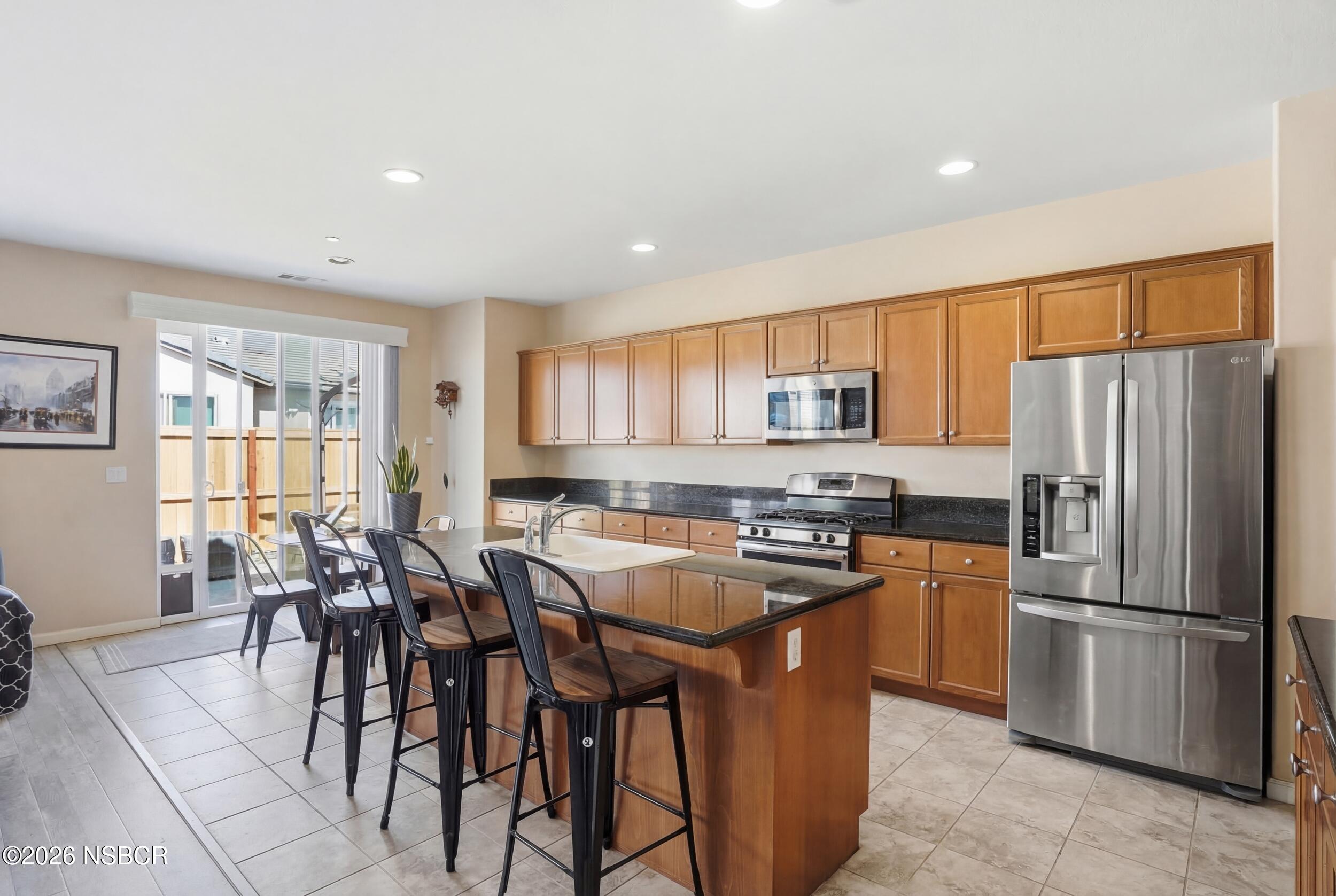 2205 Point Sal Loop Lompoc, CA 93436 - Photo 11 of 36 a kitchen with stainless steel appliances granite countertop a refrigerator a stove a sink a dining table and chairs