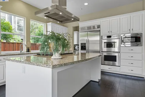 a kitchen with stainless steel appliances granite countertop a stove a refrigerator and a sink