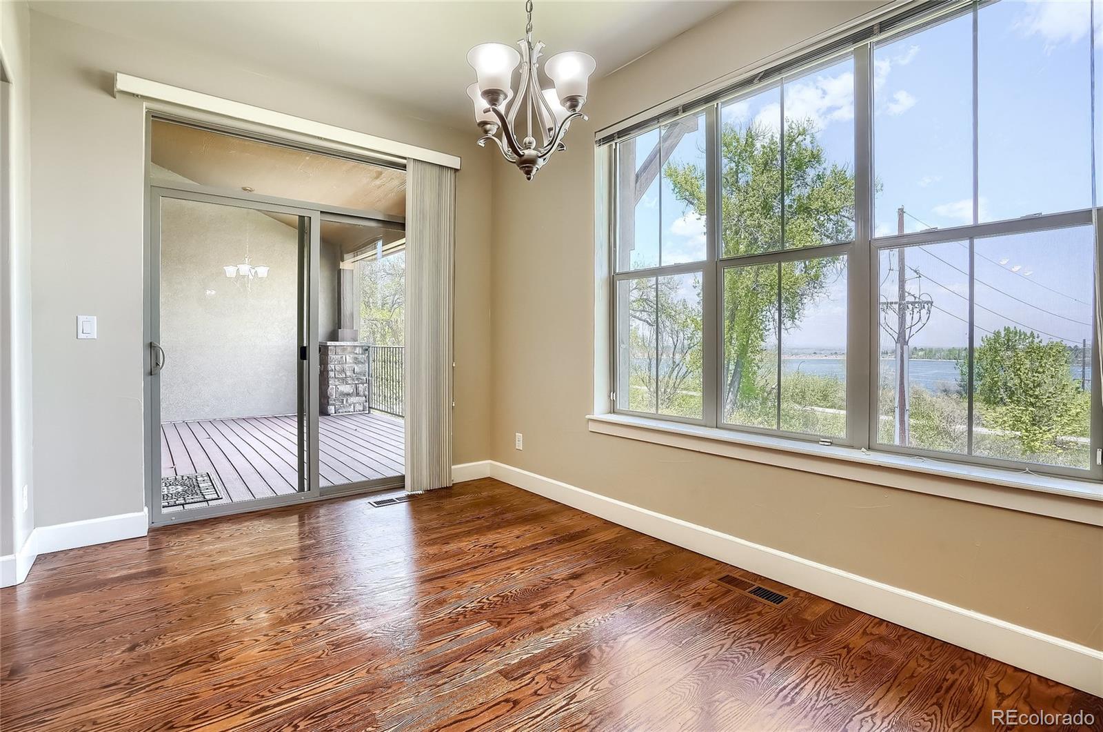 2363 Primo Road, Unit E Highlands Ranch, CO 80129 - Photo 12 of 36 a view of an empty room with wooden floor and a window