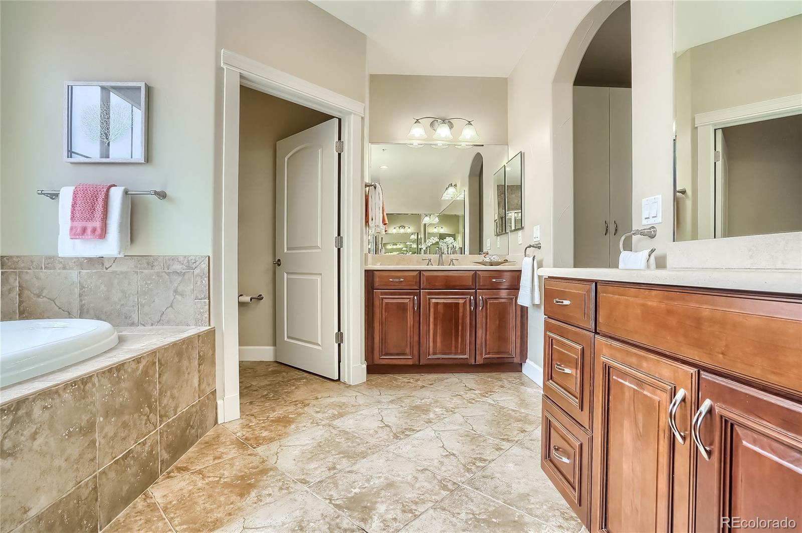 2363 Primo Road, Unit E Highlands Ranch, CO 80129 - Photo 22 of 36 a spacious bathroom with a tub sink and mirror