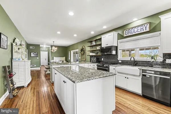 a kitchen with stainless steel appliances granite countertop a stove and cabinets