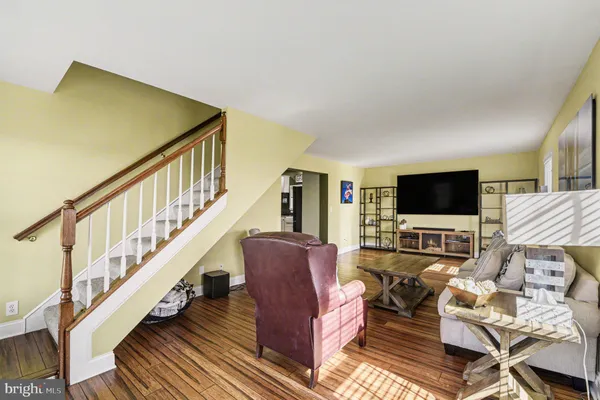 a living room with furniture or wooden floor and a flat screen tv
