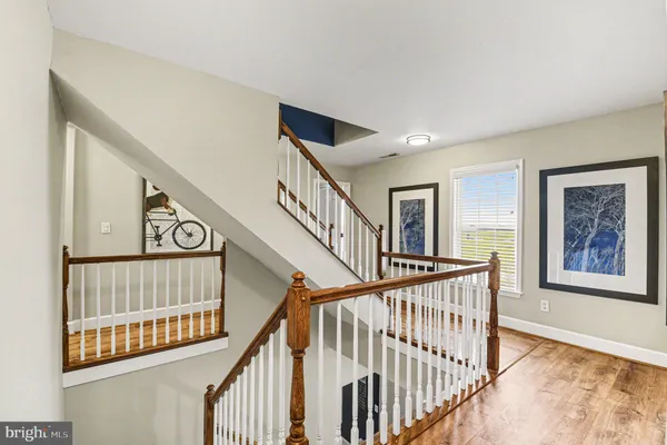 a view of staircase with lots of frames on wall and a window