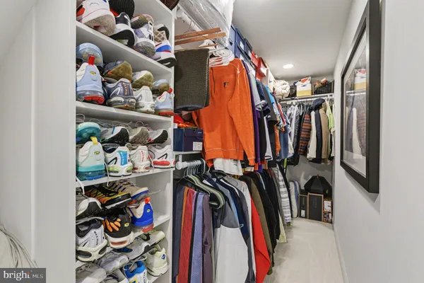 a view of walk in closet with clothes and shoes
