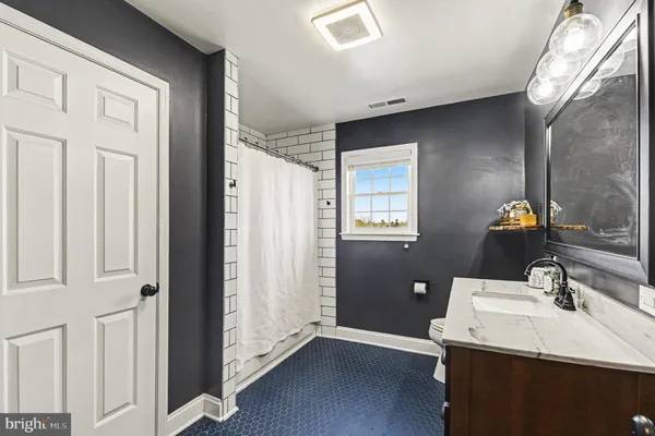 a bedroom with a bed desk and a window