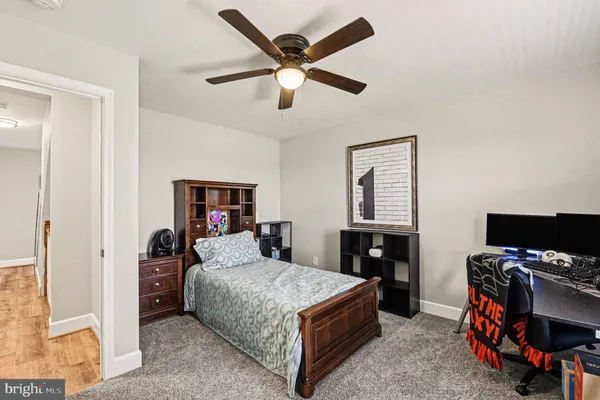 a bedroom with a bed and a flat tv screen on the dresser