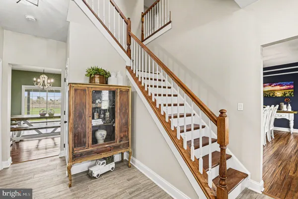 a view of staircase with lots of frames on wall and a dining table