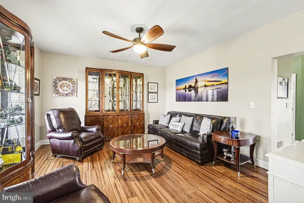 a living room with furniture ceiling fan and a window