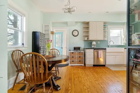 a kitchen with stainless steel appliances granite countertop a kitchen island hardwood floor and a sink