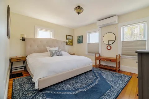 a bedroom with a bed and dresser with mirror