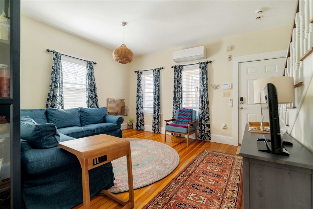 10 Gilman Street Boston, MA 02131 - Photo 7 of 41 a living room with furniture a fireplace and large windows