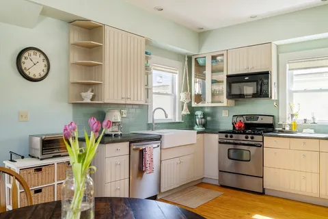 a kitchen with stainless steel appliances granite countertop a stove a sink cabinets and a window