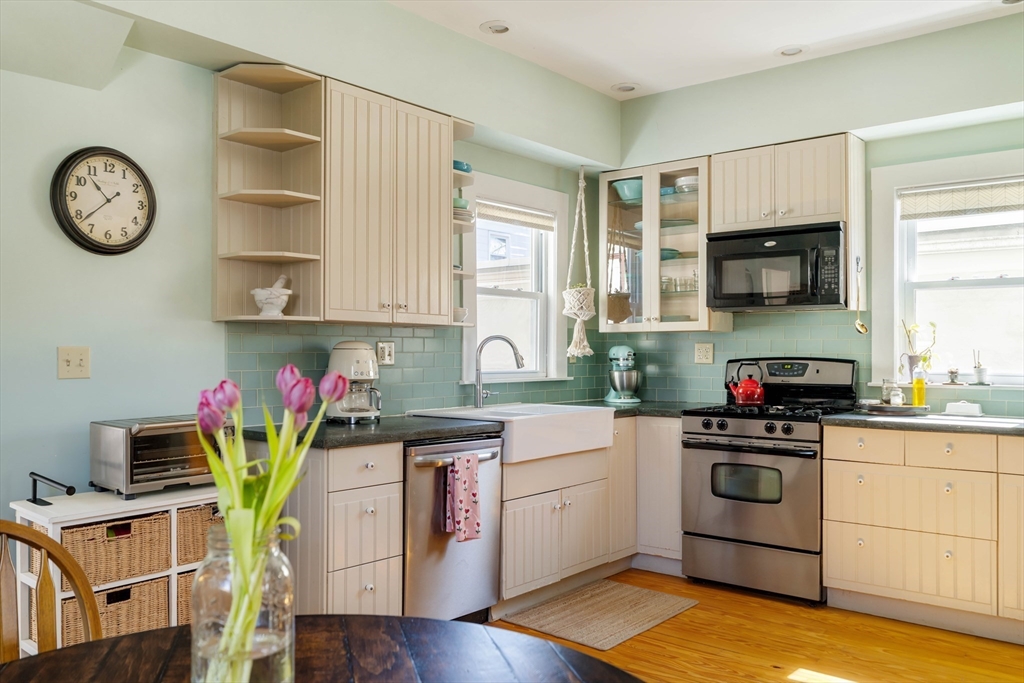 10 Gilman Street Boston, MA 02131 - Photo 10 of 41 a kitchen with stainless steel appliances granite countertop a stove a sink cabinets and a window