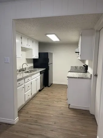 a kitchen with a sink stove and cabinets