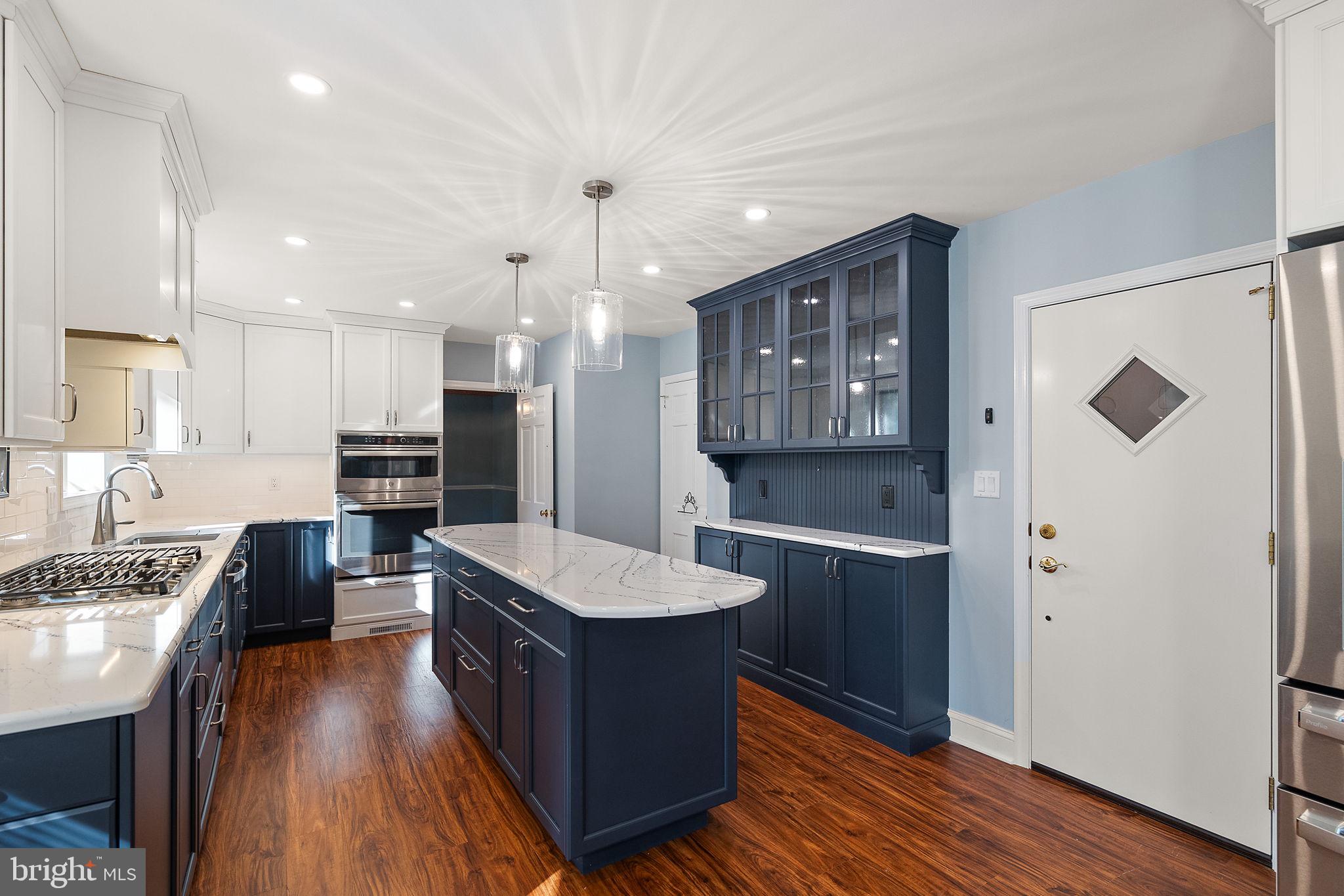 9 Granite Road Wilmington, DE 19803 - Photo 10 of 55 a large kitchen with a center island wooden floor stainless steel appliances and a window