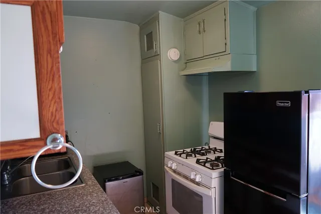 a kitchen with a stove and a wooden closet