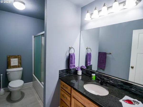 a bathroom with a granite countertop sink and a mirror