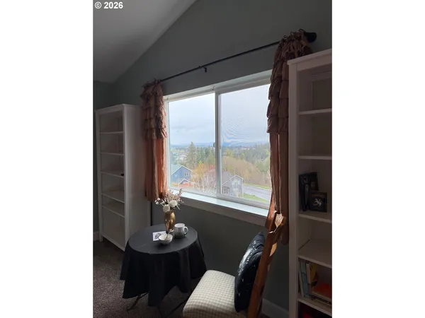 a view of a workspace room with furniture and window