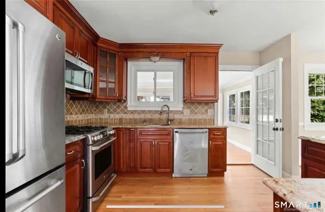 a kitchen with stainless steel appliances granite countertop a stove a sink and a microwave