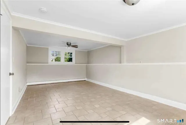 a view of an empty room with window and stairs
