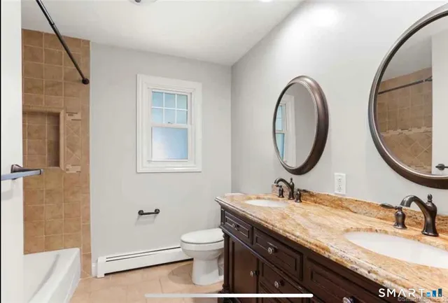 a bathroom with a granite countertop toilet a sink and a mirror