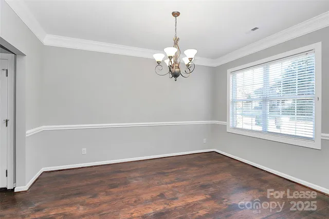 a view of a big room with wooden floor and chandelier