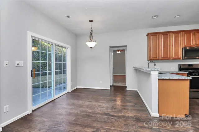 a view of a kitchen with wooden floor and a window