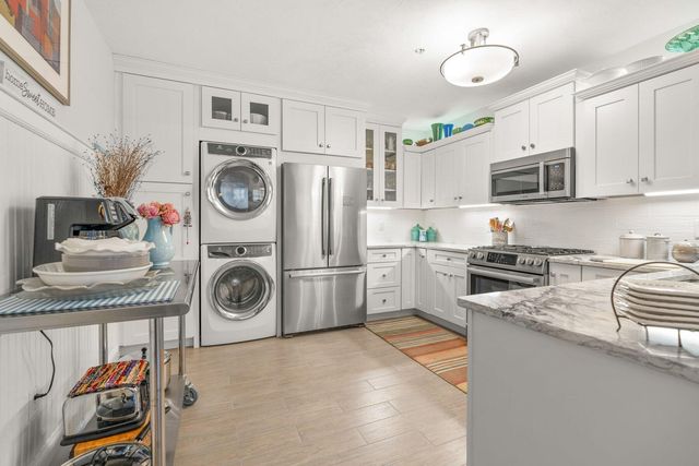 a kitchen with a refrigerator a stove top oven a sink and cabinets