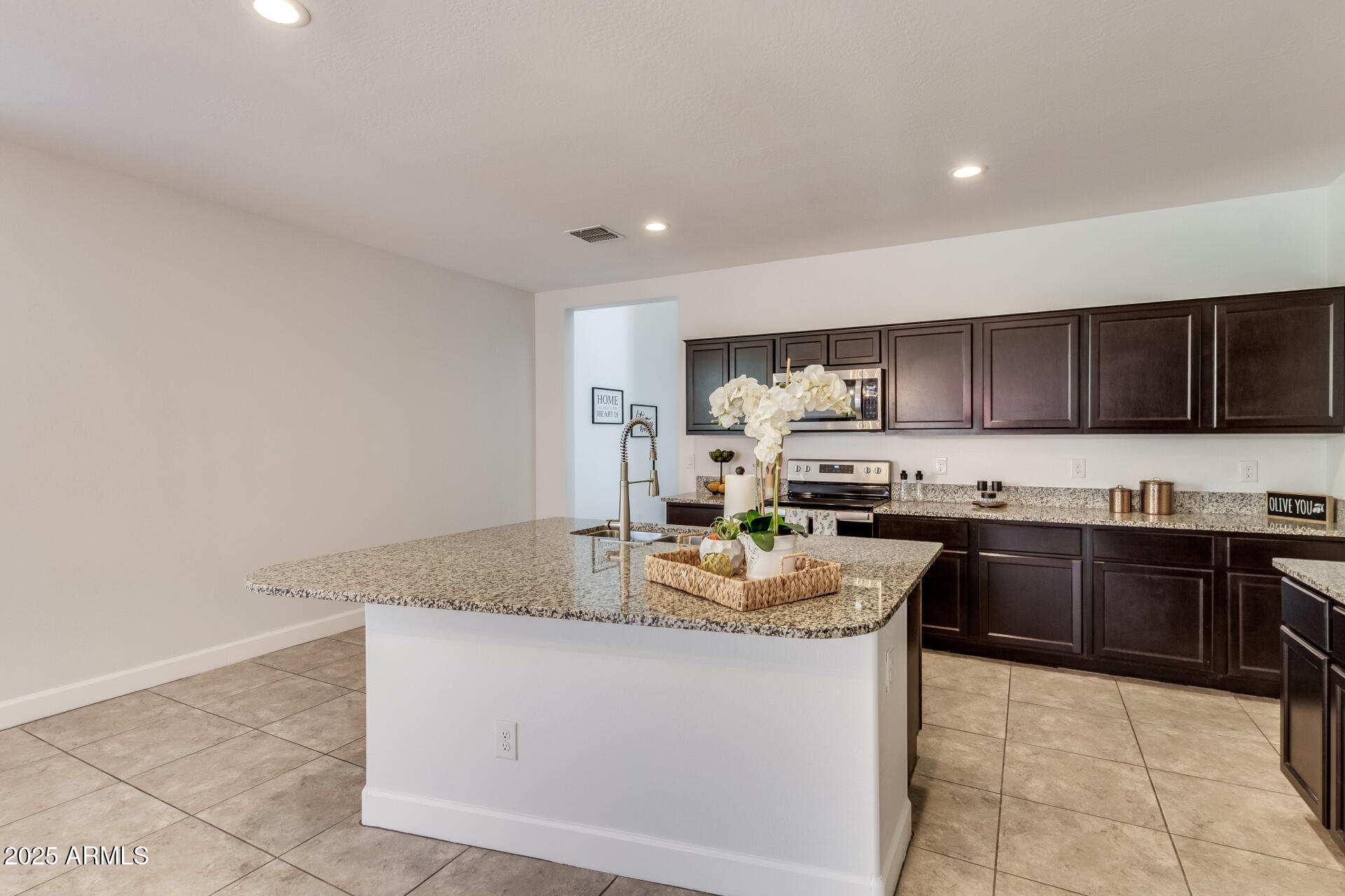 4750 East Chromium Road San Tan Valley, AZ 85143 - Photo 43 of 74 a kitchen with kitchen island granite countertop a stove sink and cabinets
