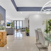 a living room with furniture a chandelier and a potted plant