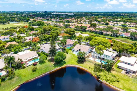 an aerial view of residential houses with outdoor space and trees