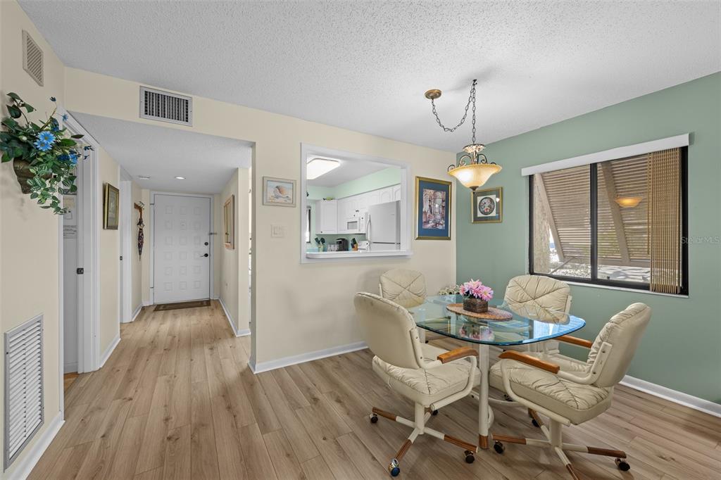 5290 Willow Links, Unit 57 Sarasota, FL 34235 - Photo 15 of 46 a dining room with furniture a chandelier and wooden floor