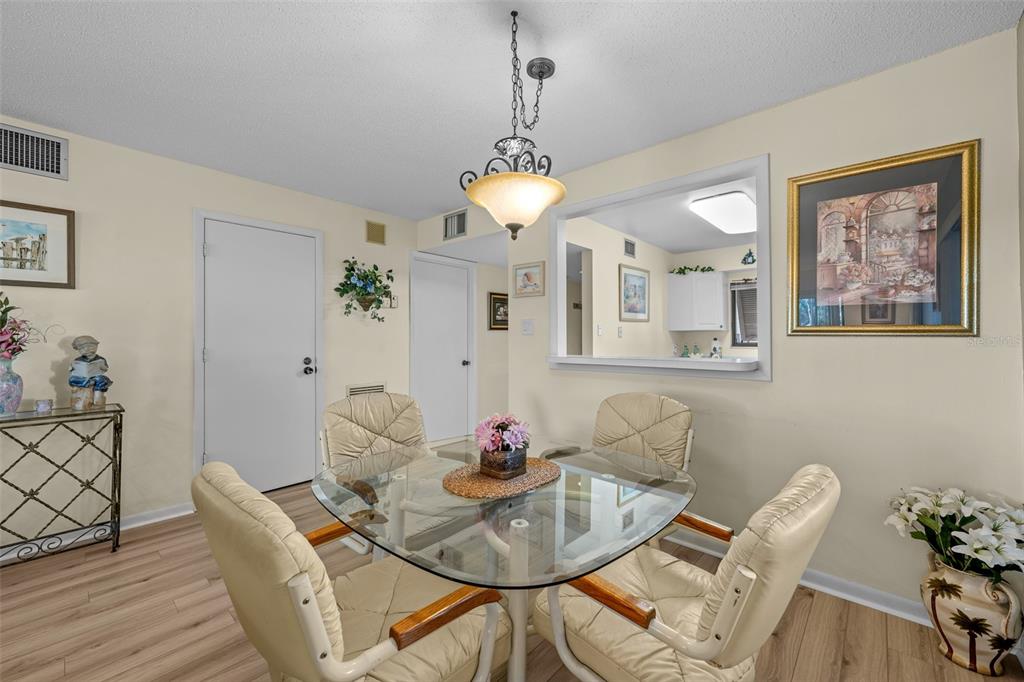 5290 Willow Links, Unit 57 Sarasota, FL 34235 - Photo 16 of 46 a dining room with furniture potted plants and wooden floor