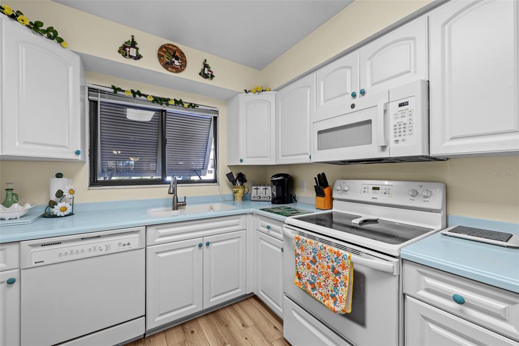 5290 Willow Links, Unit 57 Sarasota, FL 34235 - Photo 19 of 46 a kitchen with stainless steel appliances granite countertop a sink and cabinets with wooden floor