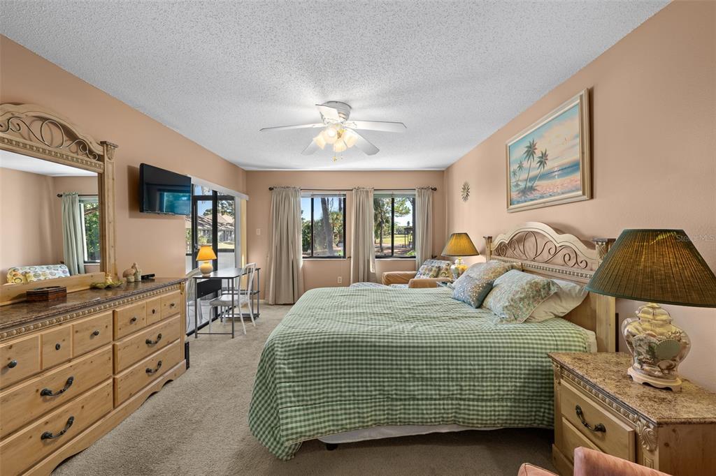 5290 Willow Links, Unit 57 Sarasota, FL 34235 - Photo 4 of 46 a bedroom with a bed and a dresser in it