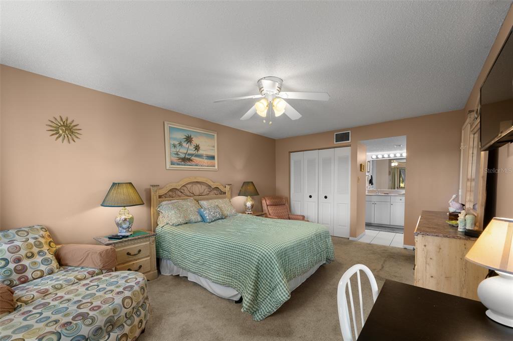 5290 Willow Links, Unit 57 Sarasota, FL 34235 - Photo 5 of 46 a bedroom with a large bed and ceiling fan