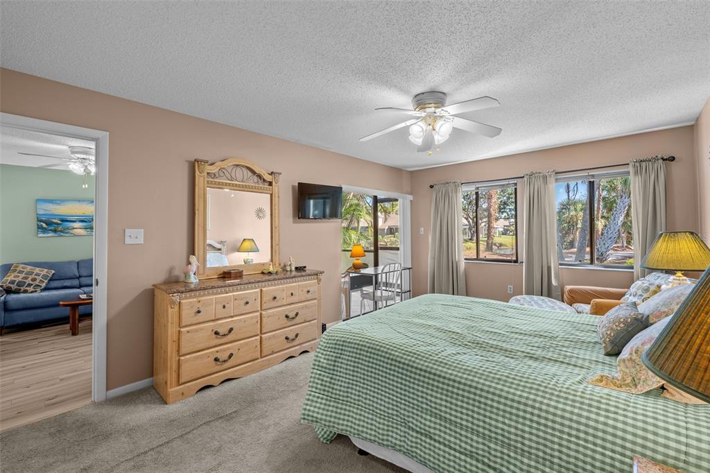 5290 Willow Links, Unit 57 Sarasota, FL 34235 - Photo 6 of 46 a bedroom with a bed and a chandelier