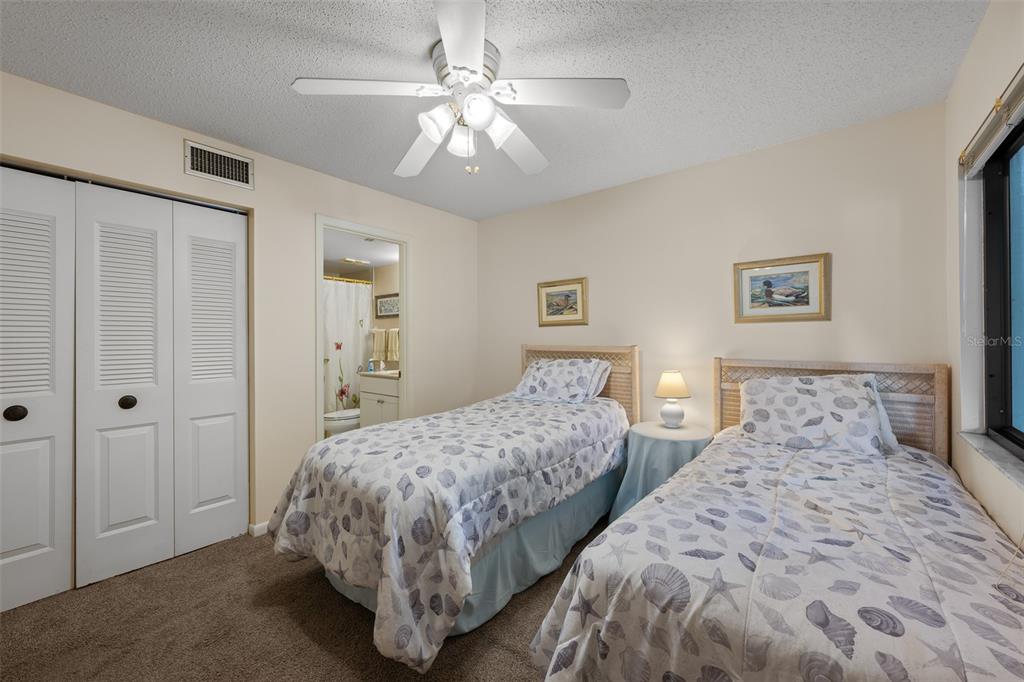 5290 Willow Links, Unit 57 Sarasota, FL 34235 - Photo 9 of 46 a bedroom with two beds and a chandelier
