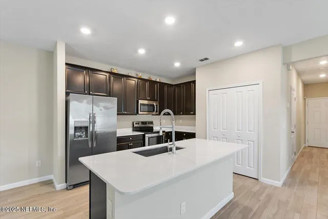 a kitchen with stainless steel appliances a refrigerator and a stove top oven